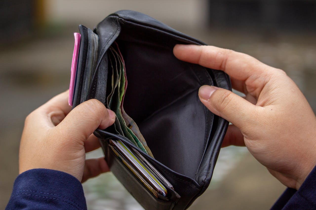 brand-02 Hands holding an empty wallet, exploring themes of financial strain and budgeting.